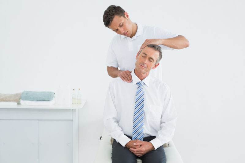 A chiropractor providing onsite care to an office office worker
